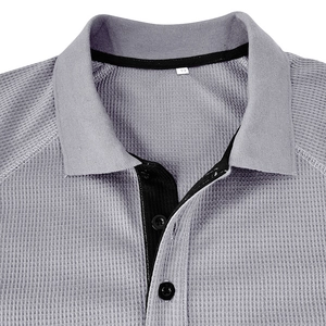 Close-up of light gray waffle knit texture and neckline detail on a men's polo shirt