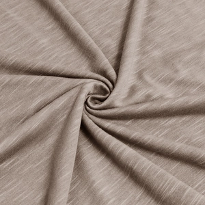 Close-up of light brown slub cotton fabric showing natural texture and soft knitted weave