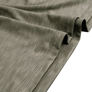 Gros plan du tissu olive à texture flammée et finitions à double couture du t-shirt