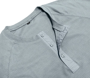 Detail of light blue waffle knit Henley T-shirt with three-button placket and M size label