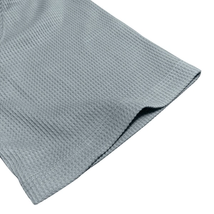 Close-up of men's waffle knit t-shirt hem showing high-quality stitching and gray texture