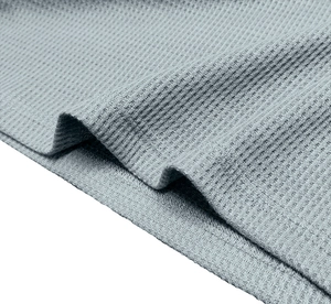 Macro shot of gray-blue waffle knit fabric texture and high-quality double-needle stitching