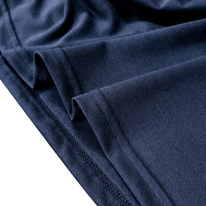 Macro shot of navy piqué fabric texture and double-needle stitching on the polo shirt