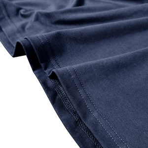 Gros plan de l'ourlet du polo bleu marine avec double couture et texture du tissu tricoté