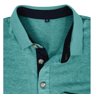 Détail du col polo bleu sarcelle avec boutons aspect bois et patte intérieure noire