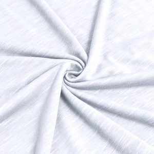 Macro detail of white slub cotton fabric showing soft texture and premium knit pattern