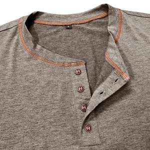 Detailed close-up of brown Henley shirt collar with four buttons and orange contrast stitching