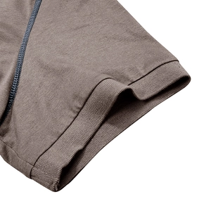 Détail du poignet côtelé d'un polo marron pour homme avec coutures bleues décoratives
