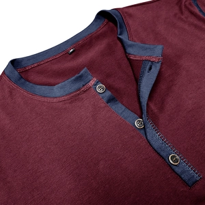 Close-up of burgundy Henley shirt neckline with navy trim and three dark wood buttons