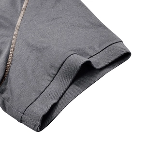 Détail de la manche d'un polo gris foncé avec bord-côte et coutures flatlock précises
