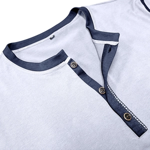 Detail of light blue Henley shirt neckline with navy trim and three brown wooden buttons