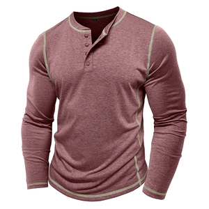 Macro detail of men's Henley shirt with brown buttons and green contrast stitching