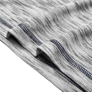 Macro detail of marled gray knit fabric and navy stitching on men's Henley shirt