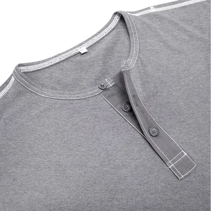 Detail of grey Henley shirt neckline featuring white contrast stitching and button closure