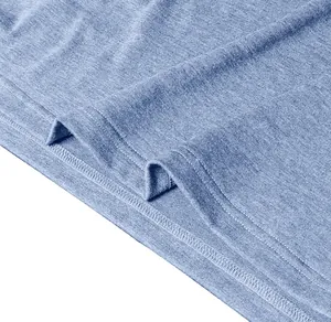 Macro shot of double-stitched hem and textured knit fabric on light blue polo shirt