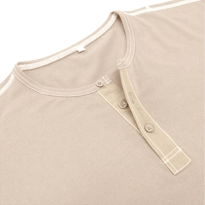 Detail of Henley collar with contrast stitching and three-button placket on beige shirt