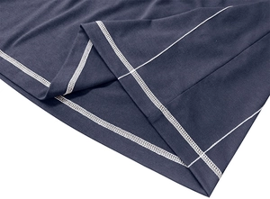 Detail of white coverstitch sewing on dark blue knitted fabric hem of the henley shirt