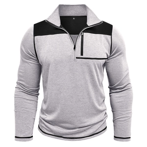 Detail of grey half-zip sweatshirt featuring black shoulder panels and vertical chest pocket