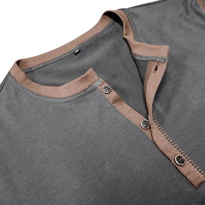Macro detail of men's Henley shirt collar with brown trim and three dark buttons