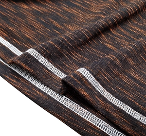 Macro shot of breathable black and orange melange knit fabric with white flatlock stitching