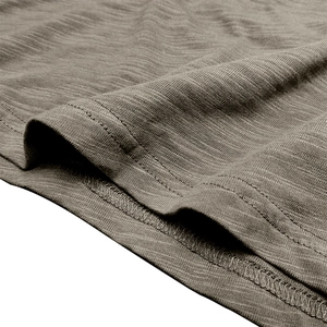 Close-up detail of slub cotton texture and double-needle hem stitching on men's top