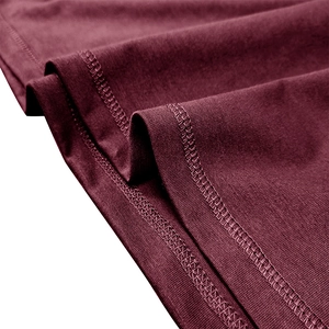 Macro shot of dark red fabric showing high-quality double-needle sewing and fine texture