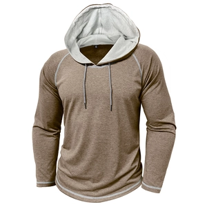 Dettaglio della felpa con cappuccio marrone da uomo con maniche raglan e cuciture premium