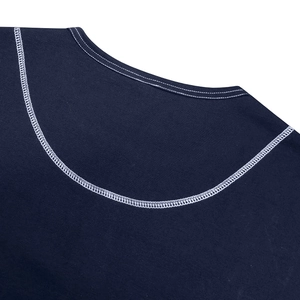 Detailed close-up of decorative white contrast stitching on a navy blue knit Henley collar