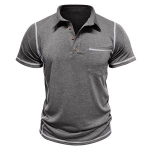 Détail d'un polo gris avec surpiqûres contrastées, poche frontale et texture raffinée