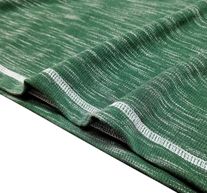 Detailed close-up of green knit fabric with textured mélange pattern and white overlock stitching