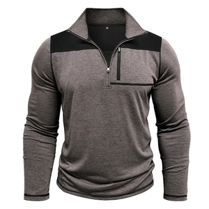 Macro detail of the men's half-zip pullover showing gray fabric and black shoulder patches