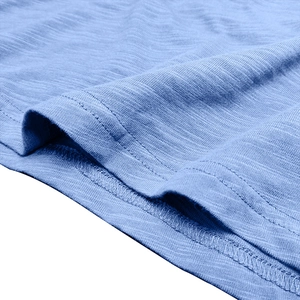 Detail of light blue shirt showing twin-needle hem stitching and slub cotton texture
