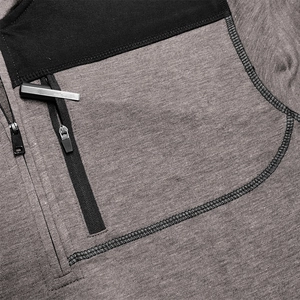 Detail of grey heather fabric with black contrast stitching and chest zipper pocket