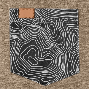 Détail du tissu chiné marron avec poche à motif topographique et étiquette en cuir