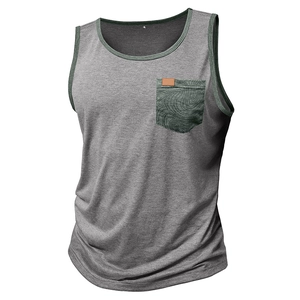 Détail d'un débardeur gris chiné avec bordures vert foncé et une poche poitrine à motif