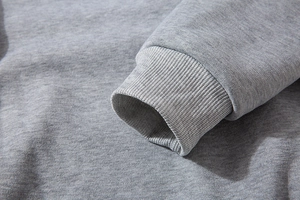 Close-up of elastic ribbed cuffs on a light grey oversize sweatshirt showing fine knitting