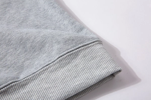 Macro shot of fine light grey knit fabric featuring reinforced ribbed cuffs and flat seams