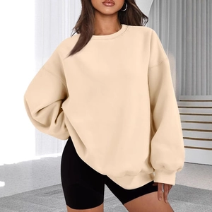 Detail view of oversized beige crewneck sweatshirt with dropped shoulders on a model