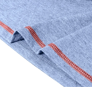 Makroaufnahme von grauem Strickstoff mit detaillierten rosa Kontrastnähten am Saum