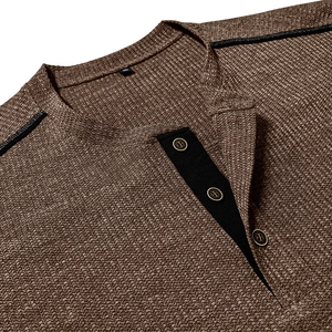 Macro detail of tan waffle knit Henley collar with three buttons and black trim finish