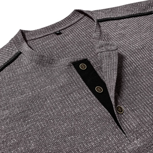 Detail showing the dark grey waffle fabric and placket with buttons on a men's Henley shirt