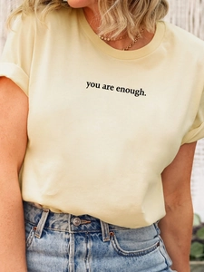 Detail eines cremefarbenen T-Shirts aus Baumwolle mit You Are Enough Textaufdruck