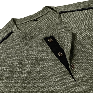 Macro detail of men's olive green waffle knit Henley shirt with buttons and shoulder stripes