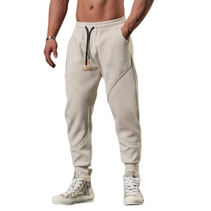 Detail view of beige joggers featuring heavy knit fabric and unique curved panel stitching