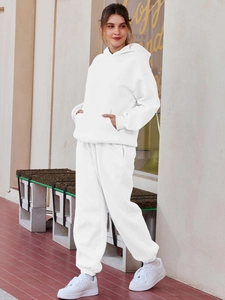 Close-up of white fleece hoodie and sweatpants set showing kangaroo pocket and fabric texture