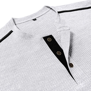 Close-up of waffle knit texture and contrast placket on light gray men's Henley shirt