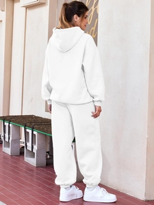 Rear view of white oversized hoodie and matching joggers set in outdoor street style