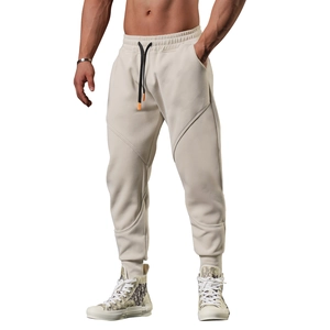 Detail showing elastic waistband with black drawstrings on men's beige joggers