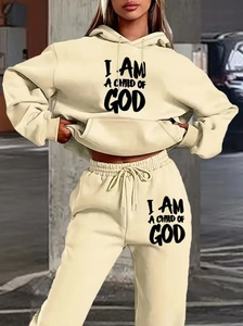 Dettaglio della tuta in pile color crema con scritta stampata I AM A CHILD OF GOD