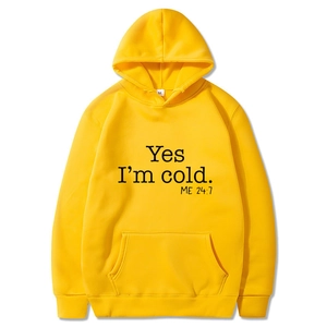 Detail of yellow hoodie with Yes I'm Cold print and ribbed cuffs on white background